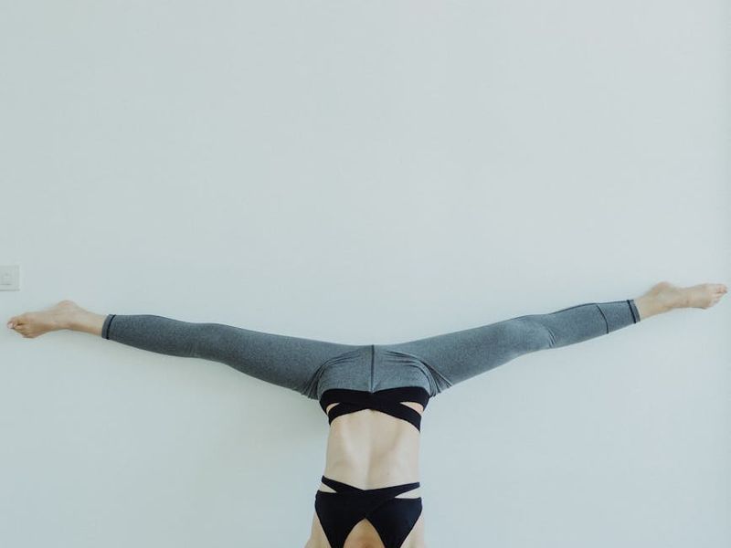 Man performing a controlled bodyweight exercise in a minimalist space.